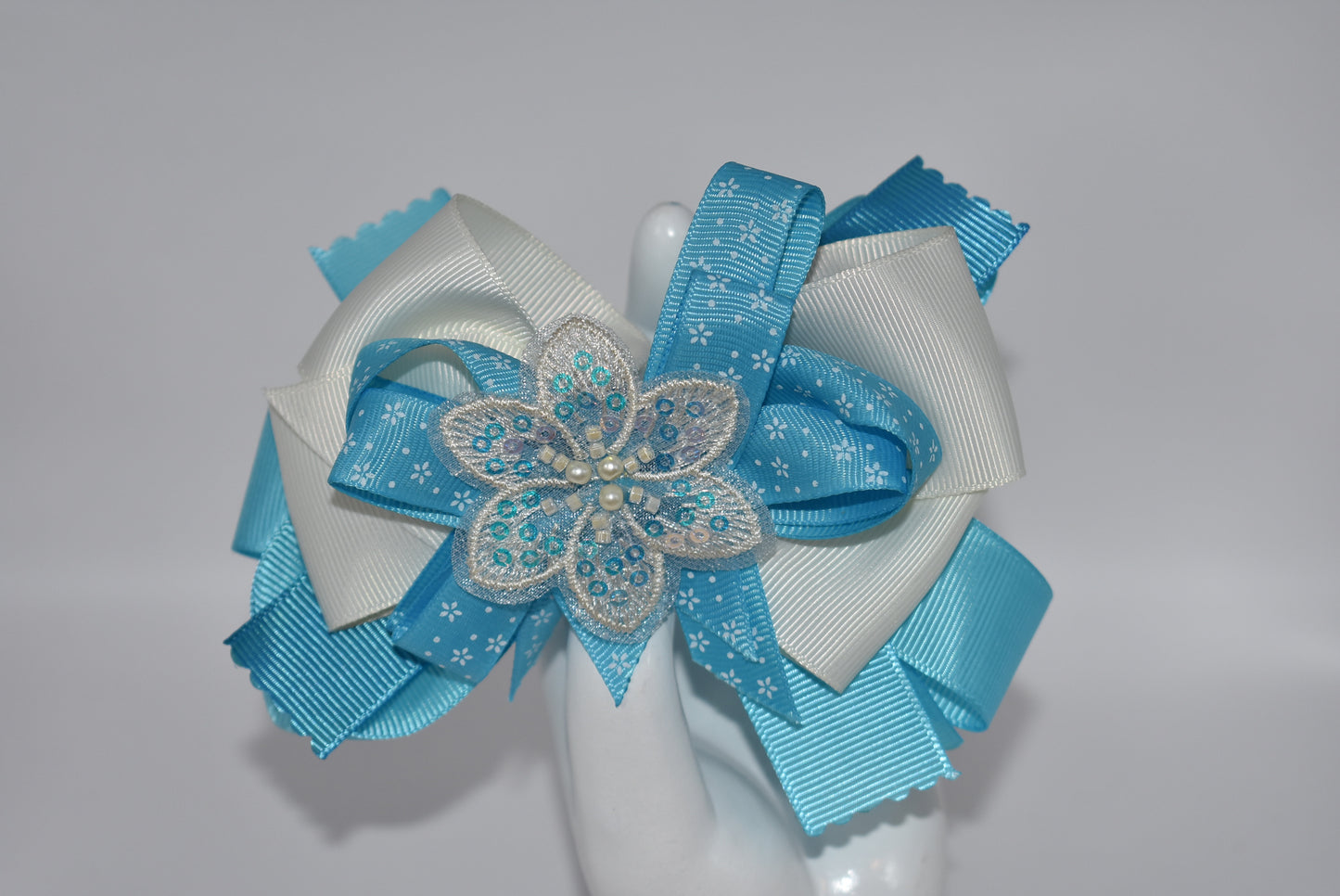 Add a splash of charm with this pretty aqua and cream ribbon adorned with a sparkly flower and tiny pearls ✨🌸. The comfy alligator clip keeps it secure while adding a touch of elegance. Simply beautiful and perfect for brightening any day! 💖🎀
