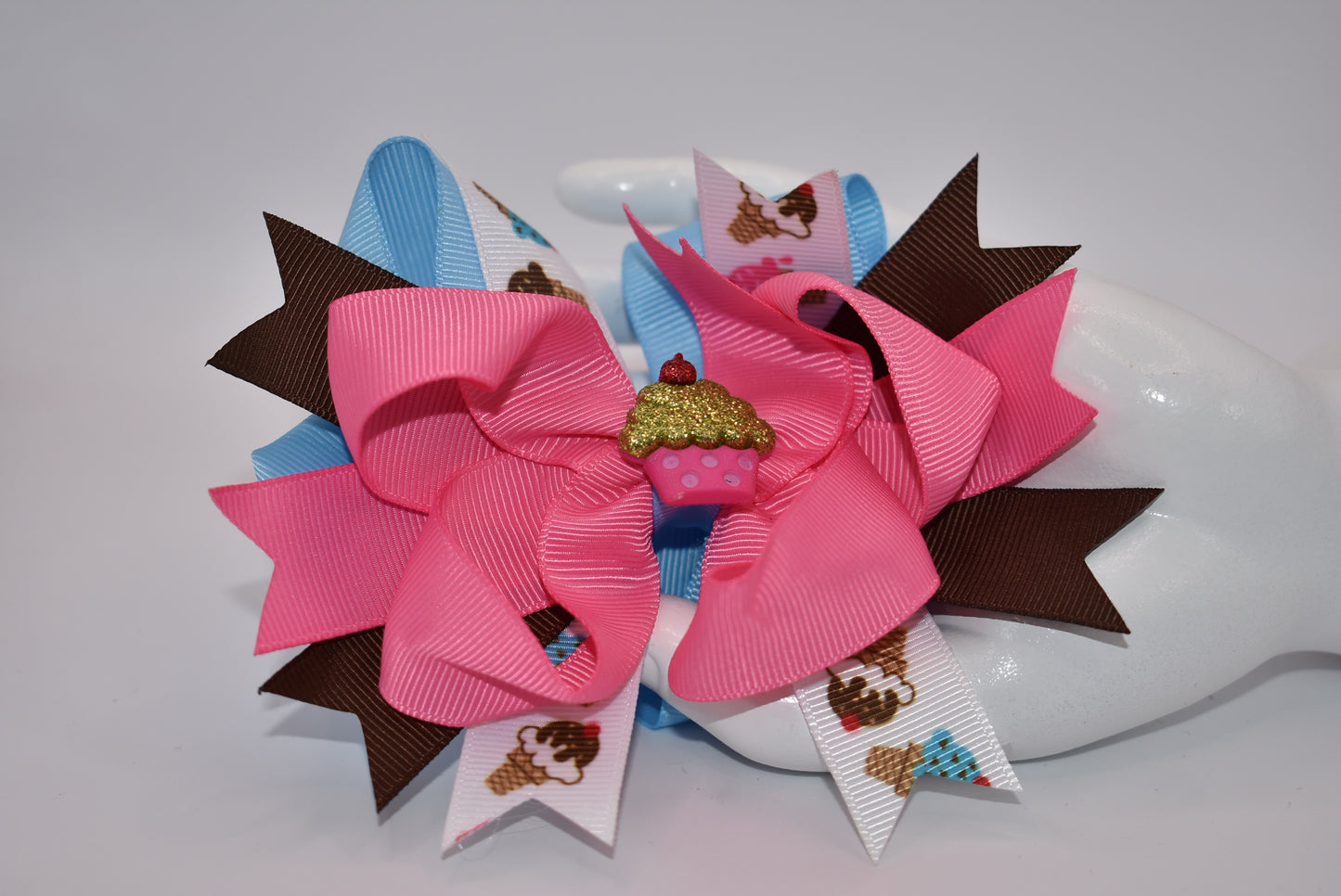 Add some flavor to your little one's style with Nana's Collection! This layered ice cream bow comes in a playful mix of brown, blue, and pink to complement any outfit. The alligator clip makes for easy on and off hair application. It's the perfect blend of fun and function.