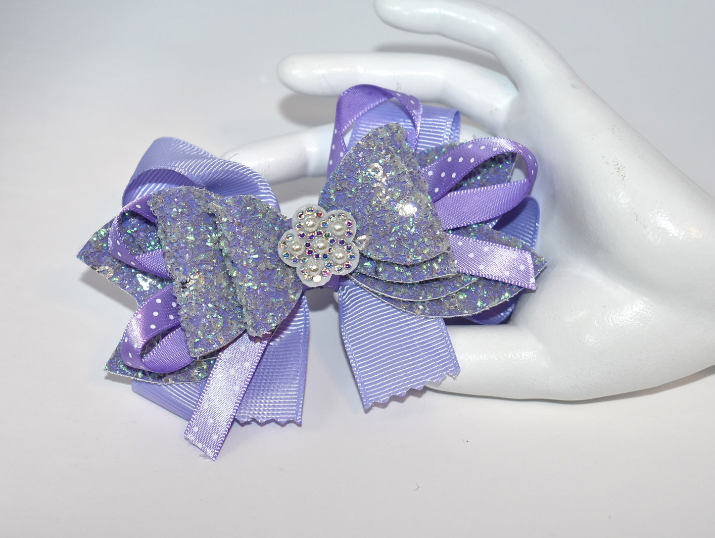 Add a splash of charm with this delightful accessory featuring a pretty lavender ribbon and sparkly faux leather, accented by a touch of purple satin polka dot ribbon π. A shiny flower and a lovely pearl top it off for extra sparkle β¨. The alligator clip ensures a secure fit, wrapped comfortably for all-day wear. Perfect for adding a playful pop to any outfit! πΈπ