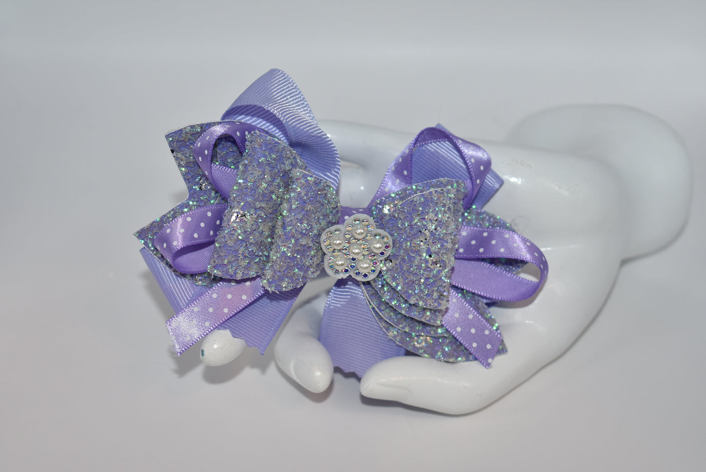 Add a splash of charm with this delightful accessory featuring a pretty lavender ribbon and sparkly faux leather, accented by a touch of purple satin polka dot ribbon π. A shiny flower and a lovely pearl top it off for extra sparkle β¨. The alligator clip ensures a secure fit, wrapped comfortably for all-day wear. Perfect for adding a playful pop to any outfit! πΈπ