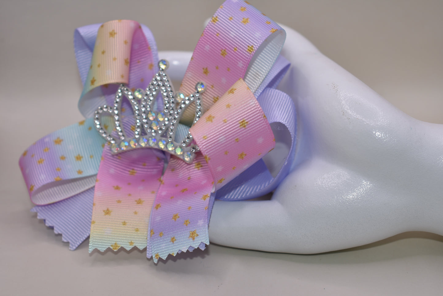 Nana's Collection presents the Perfect Princess Bow! 👑✨ This soft rainbow-colored beauty is adorned with pretty gold stars ⭐ and topped with a big sparkly crown 👸 for that royal touch! The wrapped alligator clip ensures all-day wear without slipping. 🌈 Transform any outfit into a majestic ensemble fit for your little princess! 💖
