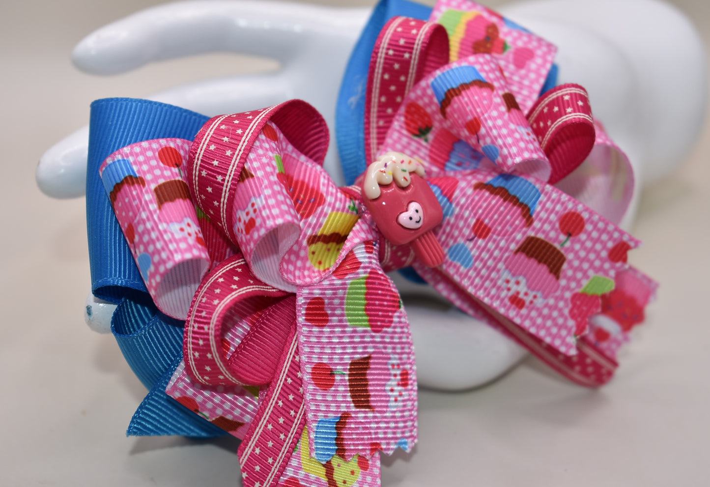 Add a splash of fun with this adorable cupcake ribbon bow, wrapped in bright, multi-colored grosgrain ribbons! 🧁✨ The cutest little charm tops it off, making it perfect for any playful outfit. Finished with a wrapped alligator clip on the back for easy wear and secure hold. 🎀💖 Perfect for adding a sweet touch to your day!