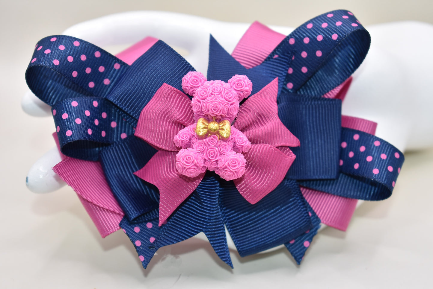 Calling all Teddy Bear lovers! 🧸 This adorable cutie from Nana's Collection 101 shines in a perfect mix of pink and navy blue. Made from high-quality grosgrain fabric, it’s soft and charming—guaranteed to steal your heart! 💖 Plus, the wrapped alligator clip on the back ensures comfy, all-day wear wherever you go. Clip it, love it, and let the fun begin! 🎀🐻