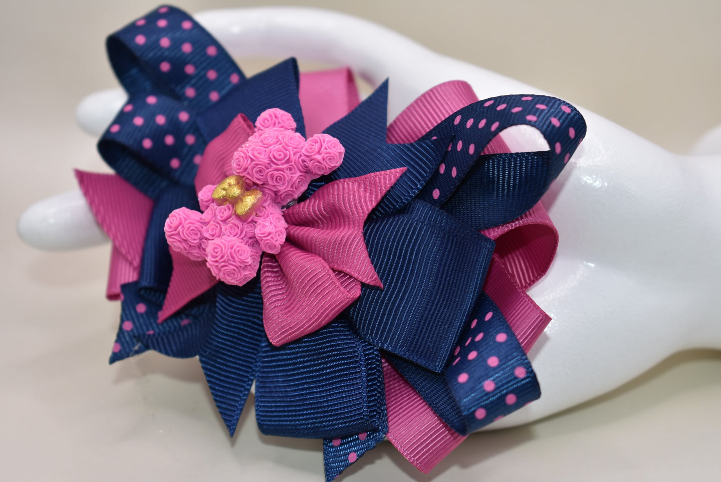 Calling all Teddy Bear lovers! 🧸 This adorable cutie from Nana's Collection 101 shines in a perfect mix of pink and navy blue. Made from high-quality grosgrain fabric, it’s soft and charming—guaranteed to steal your heart! 💖 Plus, the wrapped alligator clip on the back ensures comfy, all-day wear wherever you go. Clip it, love it, and let the fun begin! 🎀🐻