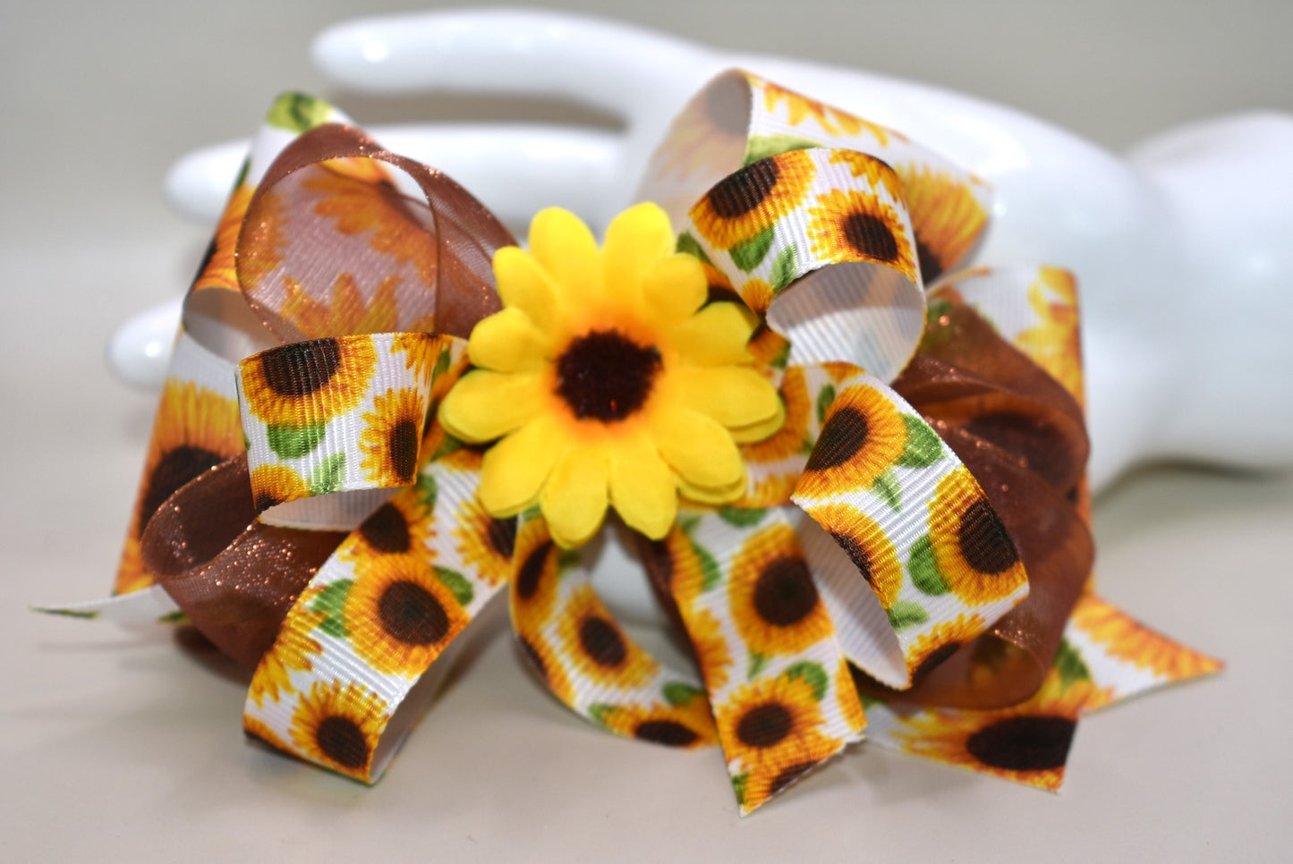 Brighten any day with this playful sunflower bow! 🌻 Layers of cheerful sunflower ribbons stacked just right, topped with a vibrant sunflower bloom for that perfect pop. Easy to wear with a handy alligator clip on the back—ready to add sunshine to your style! ☀️😊
