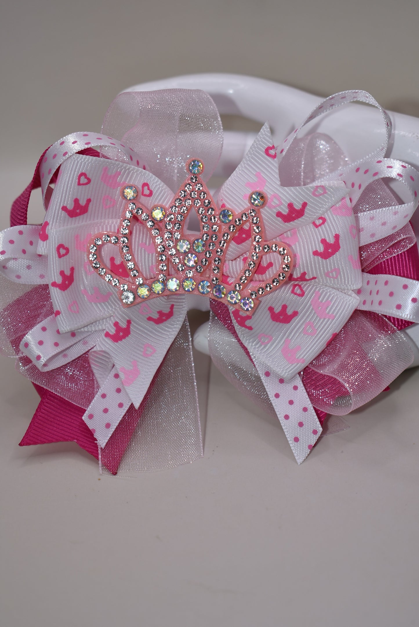 Add a touch of magic with this perfect pink princess bow! 🎀 Layers of ribbon featuring a charming princess motif come together topped with a sparkling pink glitter crown 👑. This one-of-a-kind bow clips securely with an alligator wrapped clip, making it a delightful accessory for any little princess. ✨