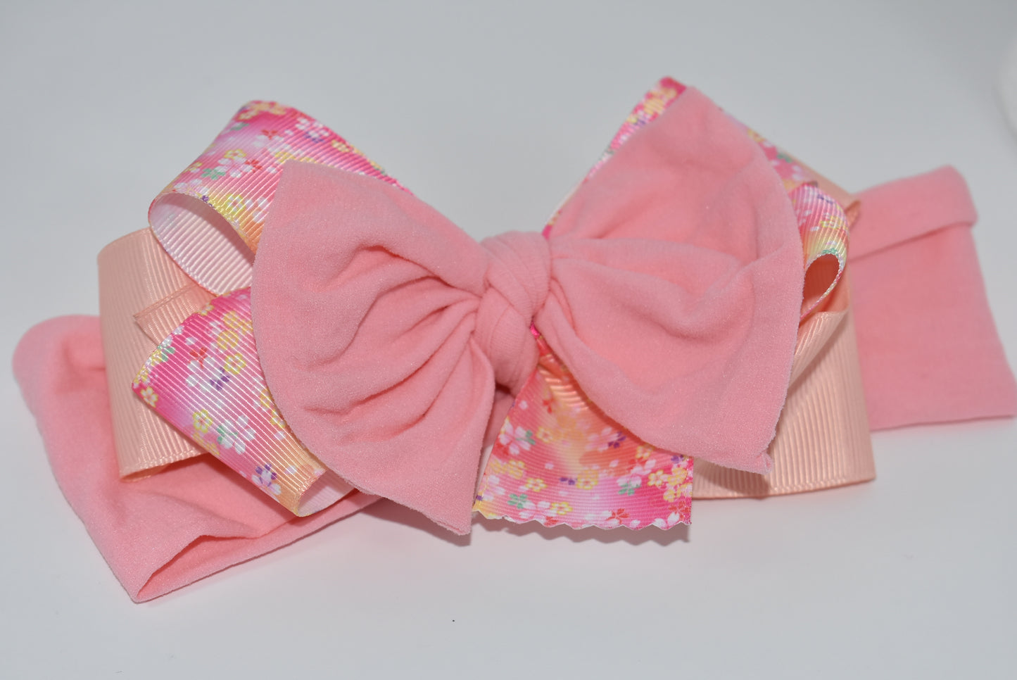 Wrap your hair in sweetness with this charming headband! 🎀 Featuring delicate layers of ribbon and soft nylon, it's designed for all-day comfort without the fuss. The pretty pink hue and cheerful floral pattern add a fun, feminine touch to any outfit. 🌸 Whether you're heading to brunch or running errands, this wrapped beauty keeps your style on point while keeping strands in place. Perfect for anyone who loves a pop of color and playful elegance! ✨