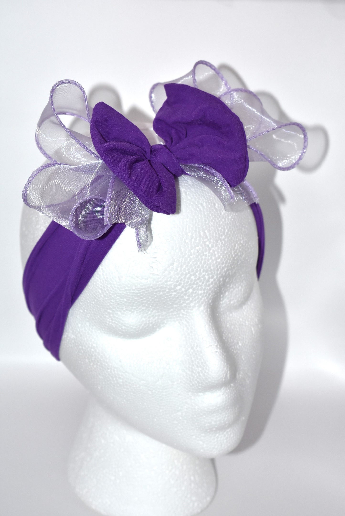 Add a vibrant pop of purple with this wide, soft headband from the Wrapped Headband Collection! 🌸 Featuring a delicate organza bow right in the center, it brings extra charm and love 💜 Perfect for all ages, it's the playful accessory you need to brighten any outfit! ✨