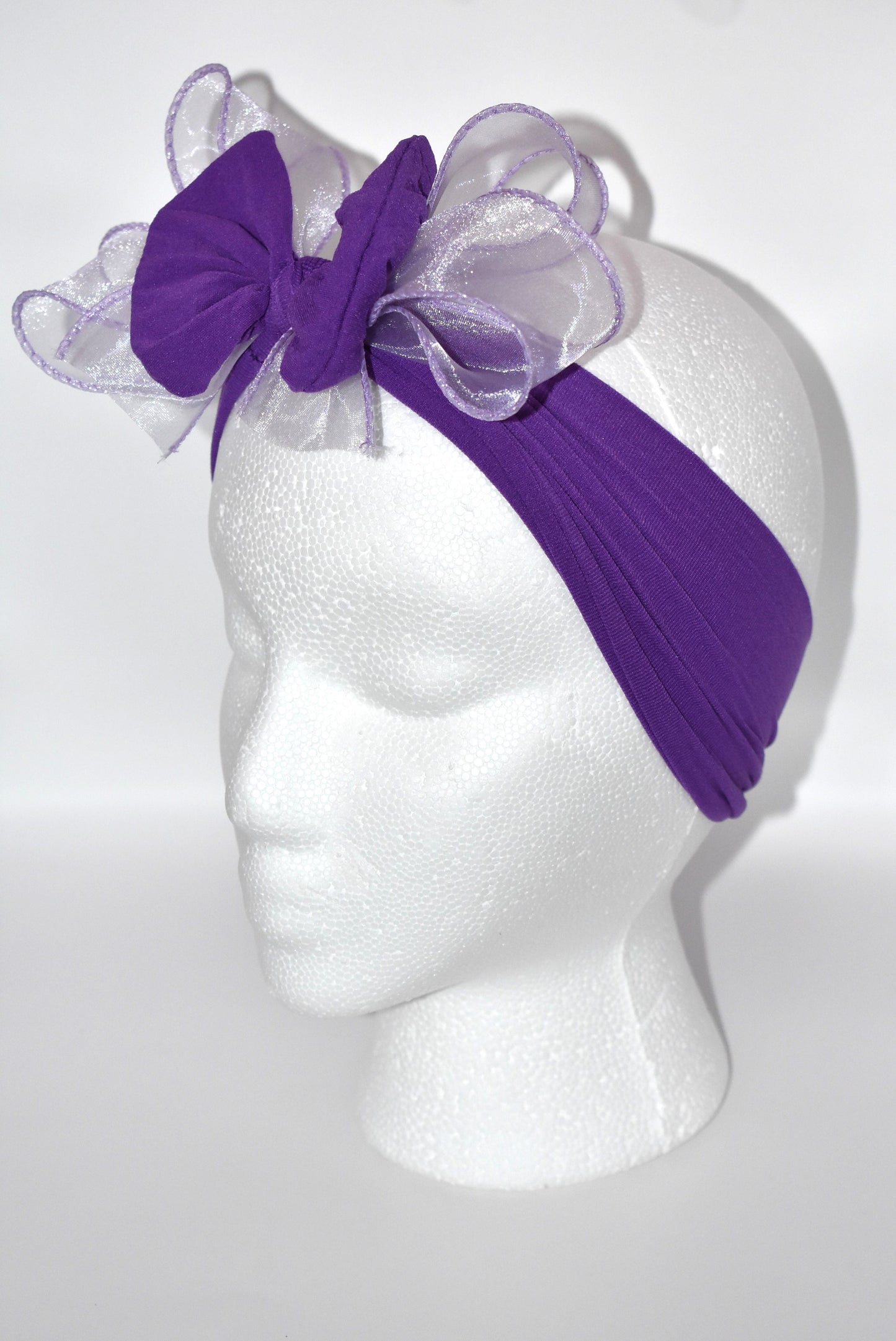 Add a vibrant pop of purple with this wide, soft headband from the Wrapped Headband Collection! 🌸 Featuring a delicate organza bow right in the center, it brings extra charm and love 💜 Perfect for all ages, it's the playful accessory you need to brighten any outfit! ✨