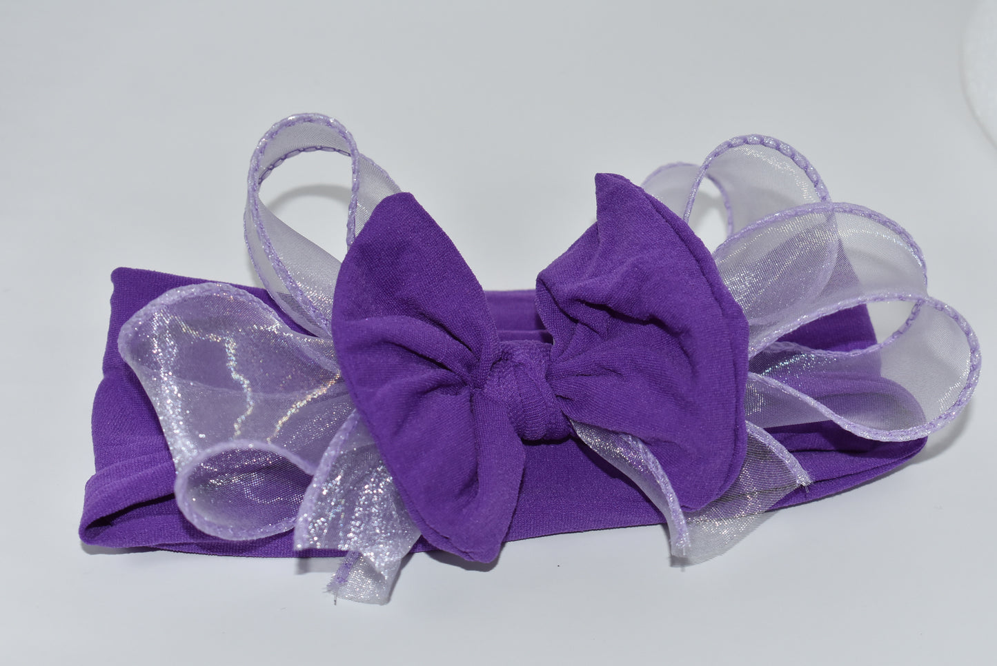 Add a vibrant pop of purple with this wide, soft headband from the Wrapped Headband Collection! 🌸 Featuring a delicate organza bow right in the center, it brings extra charm and love 💜 Perfect for all ages, it's the playful accessory you need to brighten any outfit! ✨