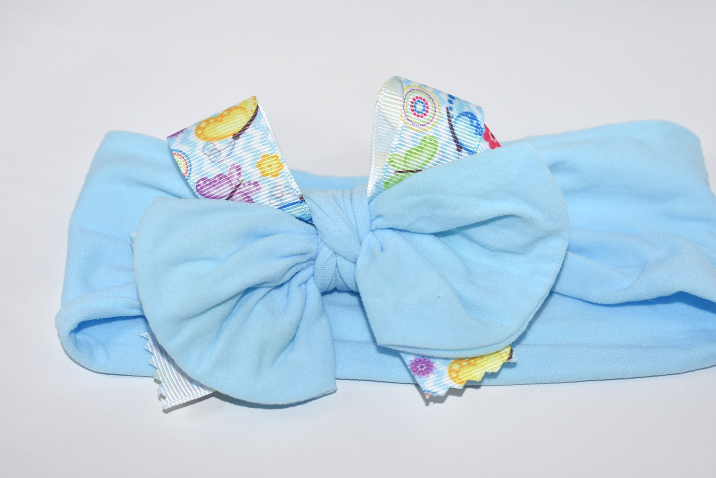 Slip on this adorable powder blue nylon headband and let your style flutter! 🦋 Wrapped in a charming butterfly and flower ribbon, this stretchy beauty hugs comfortably for all-day wear. Whether you're dressing up or keeping it casual, this versatile accessory works with every outfit and suits every age. 🌸 A playful pop of color that's as sweet as it is practical!
