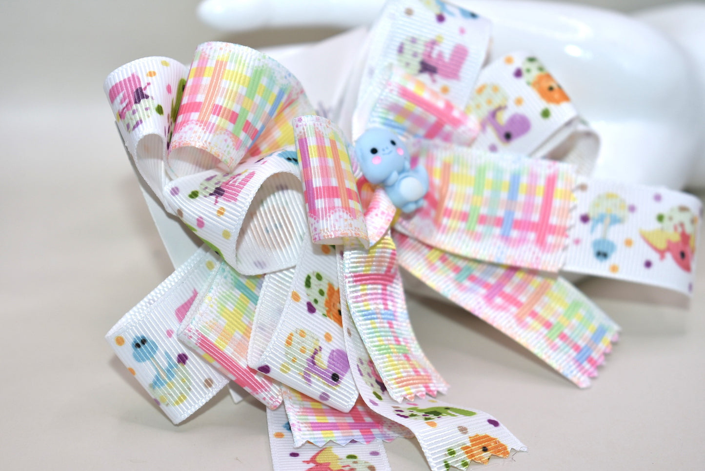 Get ready for a roar-some time with Nana's Collection 177! 🦕 This adorable dinosaur bow features layers and layers of fun dinosaur ribbon, topped with the cutest little blue dino you’ll ever see. 🦖 Secure and comfy, it clips on with a wrapped alligator clip — perfect for playtime adventures or adding a whimsical touch to any outfit! 🎀🦕