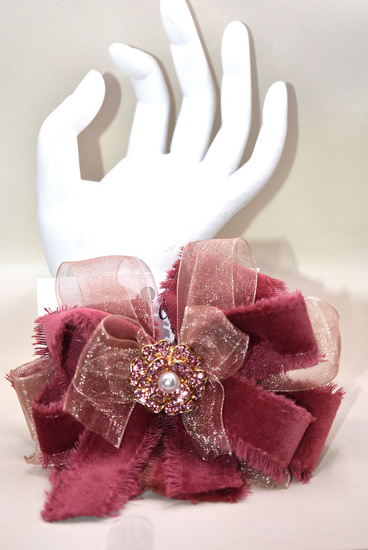 Add a playful pop of color with this gorgeous burgundy velour ribbon accented by soft pink organza. Perfect for dressing up a special outfit for you or your little one, it features a wrapped alligator clip for secure, all-day wear. A sparkling pink rhinestone and pearl piece crowns the top, tying the whole look together with charming sparkle.