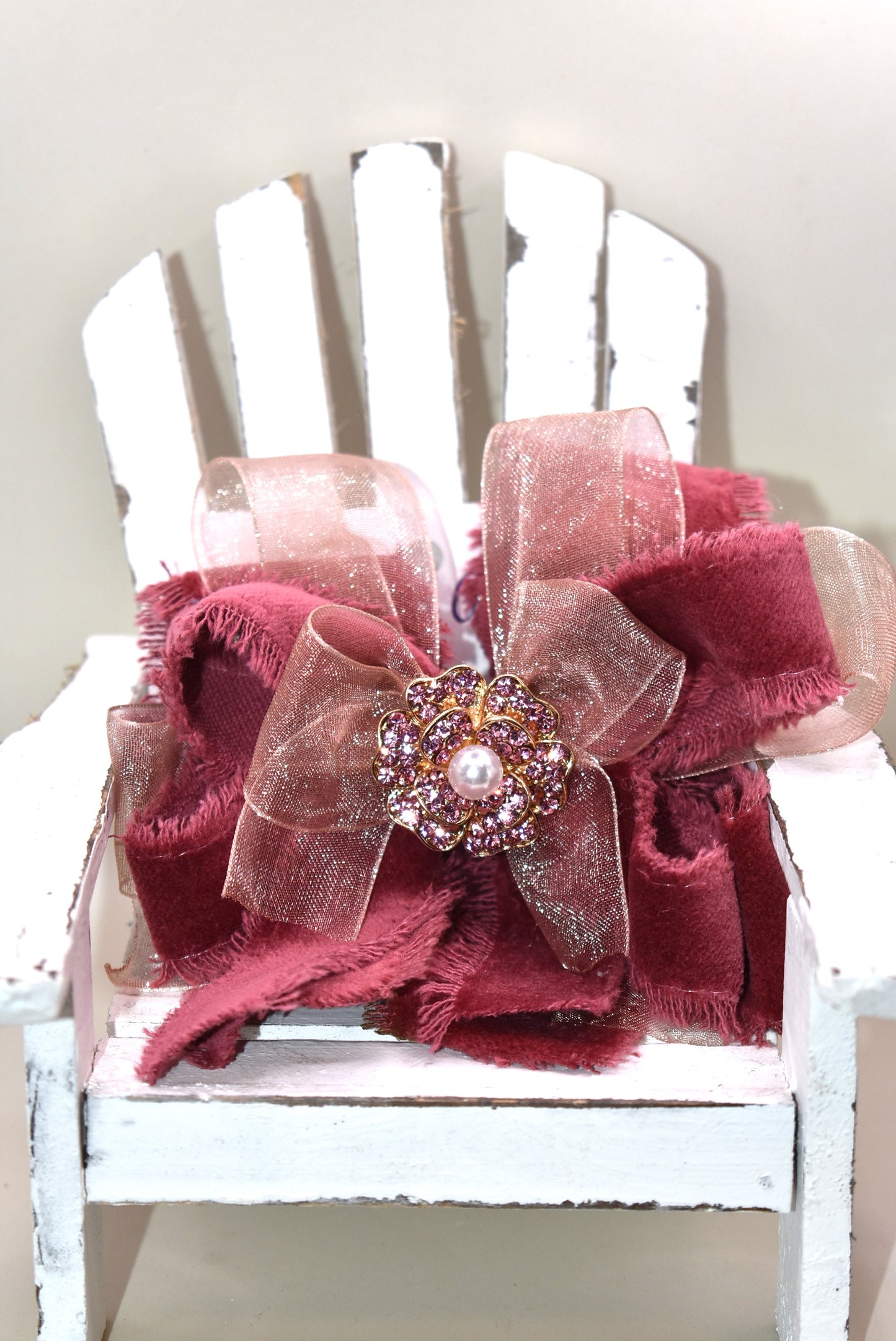 Add a playful pop of color with this gorgeous burgundy velour ribbon accented by soft pink organza. Perfect for dressing up a special outfit for you or your little one, it features a wrapped alligator clip for secure, all-day wear. A sparkling pink rhinestone and pearl piece crowns the top, tying the whole look together with charming sparkle.
