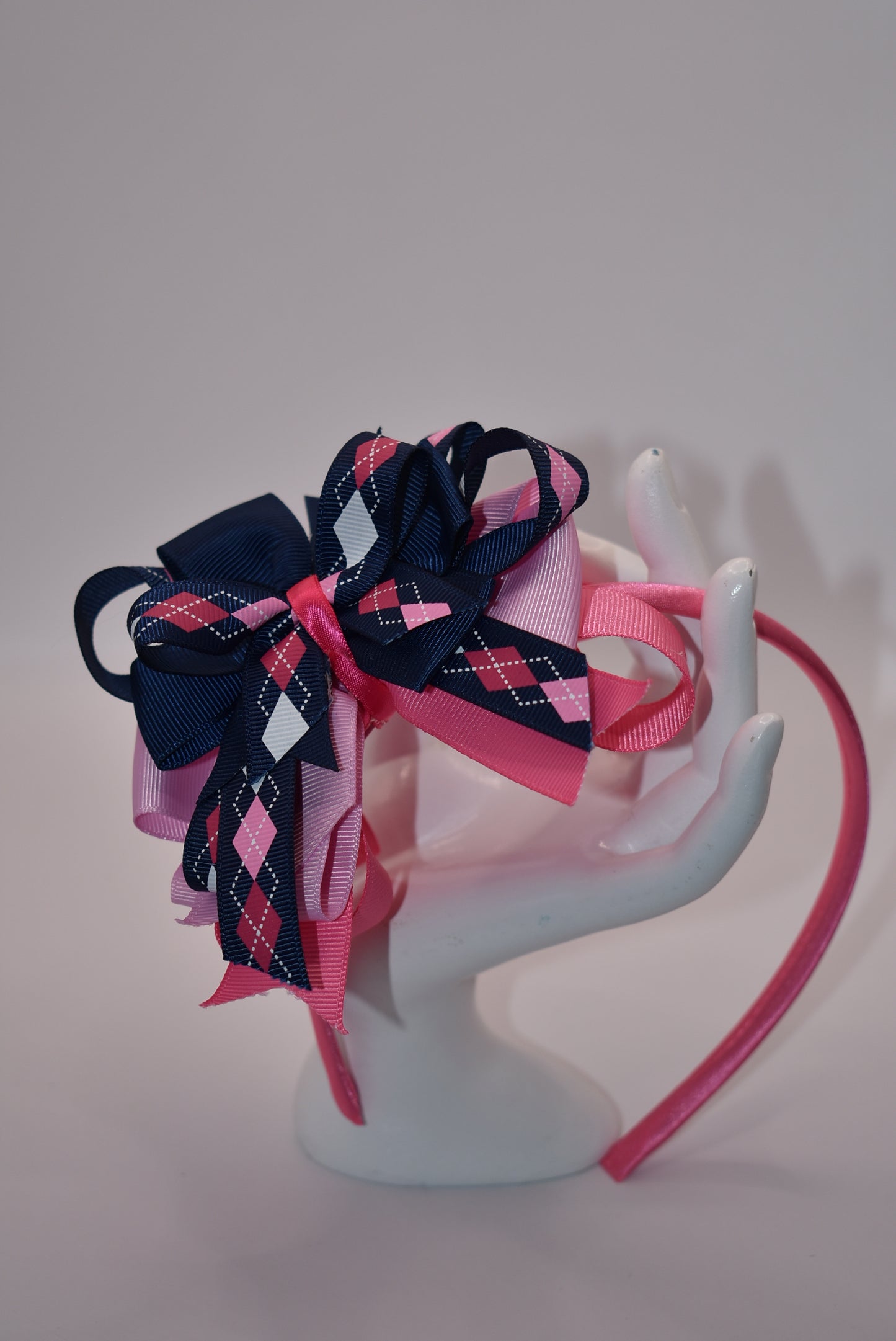 Elevate your style with Nana's Headband Collection! The cool blue, pink and white color combination is perfect for any outfit. The pretty pink satin-wrapped headband adds a touch of elegance, while the layers of quality ribbon give it a unique charm. Say goodbye to boring hair days with this playful and stylish accessory.