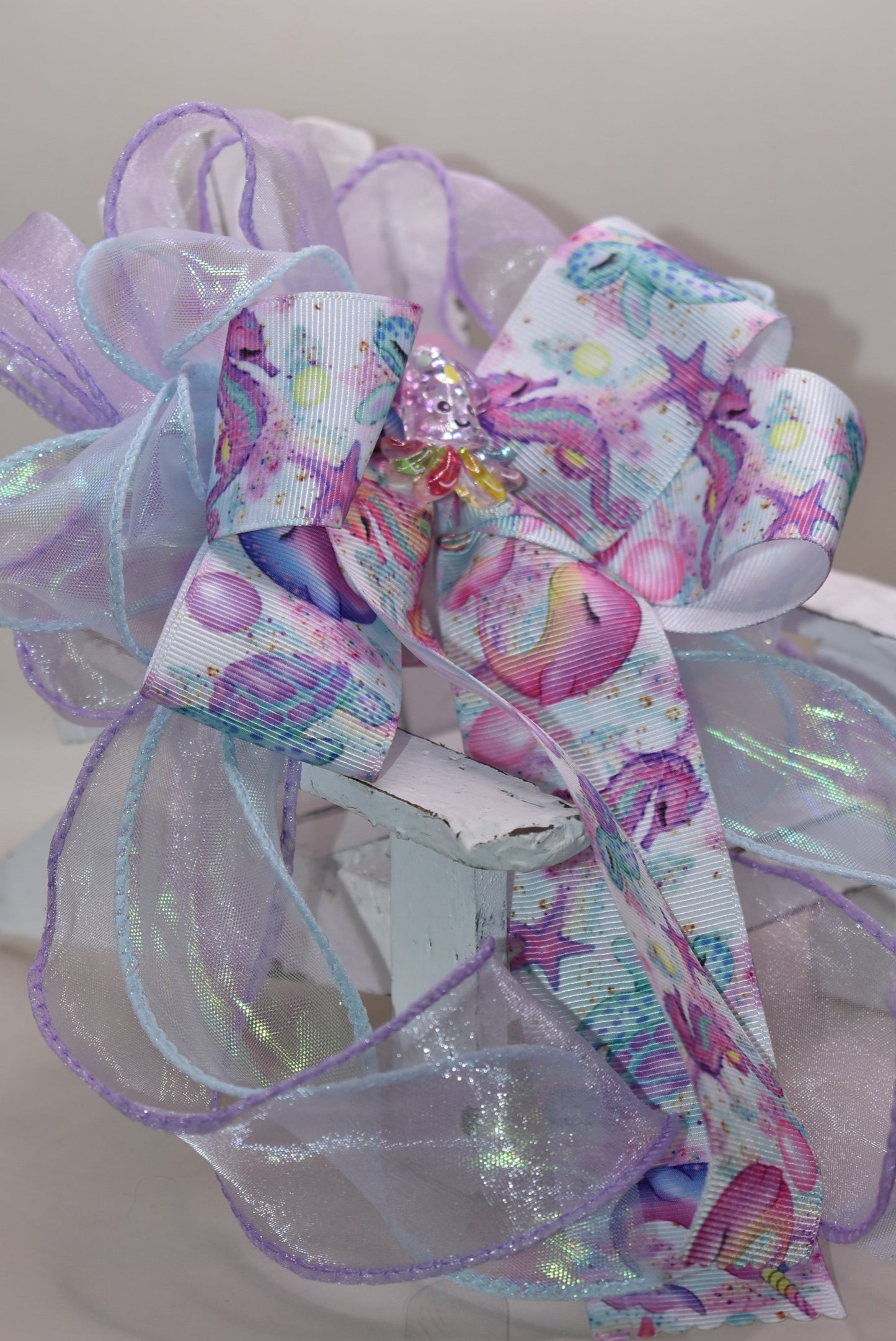 Make a splash with this playful nautical-themed long bow! Layers of beautiful ribbon cascade gracefully, topped with the cutest octopus charm 🐙 for an adorable touch. Featuring a French barrette clip with a snap-on closure, it ensures a perfect fit for any hair adventure. Perfect for adding a sea-inspired charm to your look! ⚓🌊