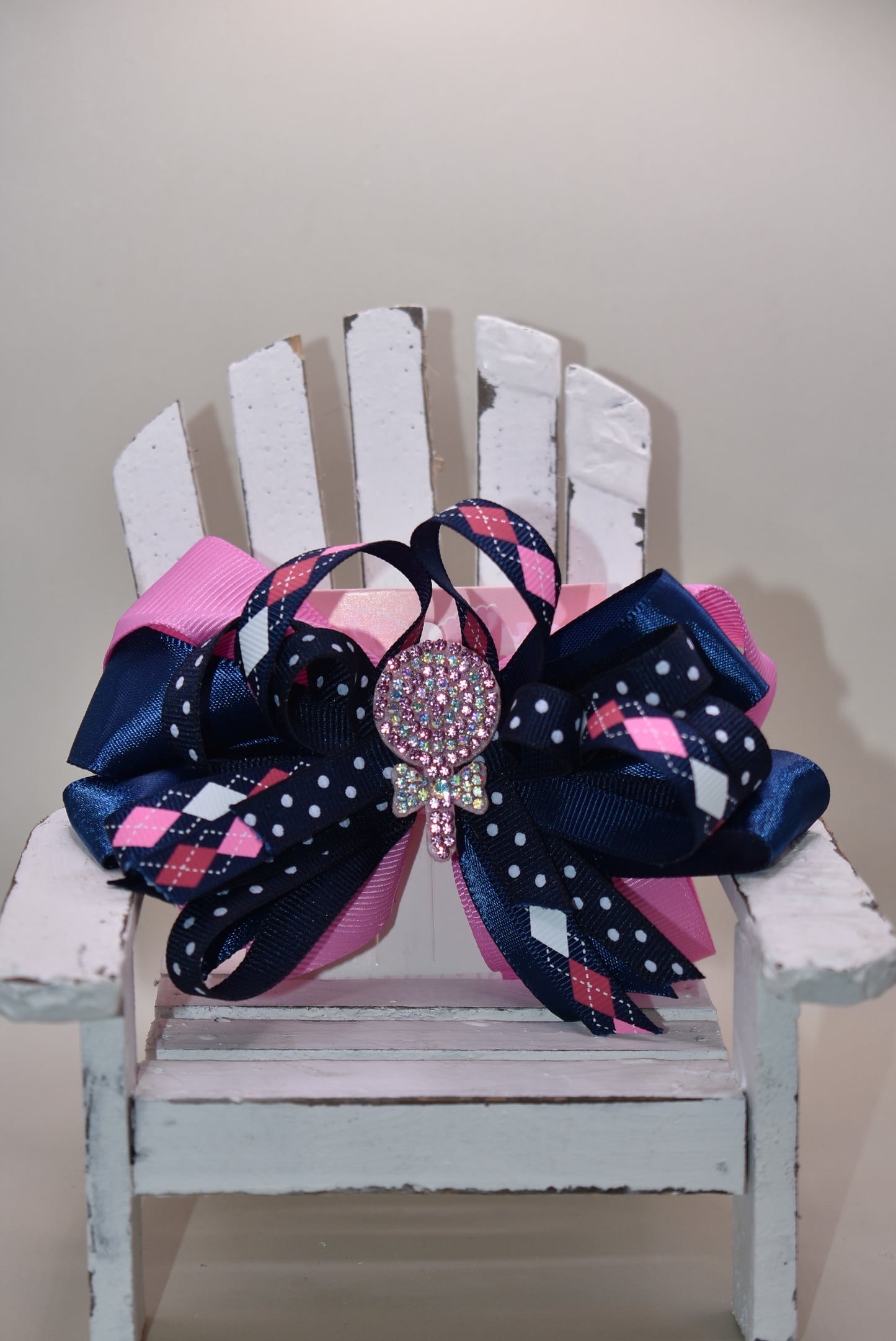 Add a pop of fun with this playful bow from Nana's Collection! Layers of pretty blue and pink ribbons create a charming swirl topped with a sparkling candy embellishment that’s sure to catch the eye 🍬✨. Perfect for adding a little extra sparkle to any outfit, it stays put all day thanks to a handy wrapped alligator clip. Sweet style made easy! 🎀