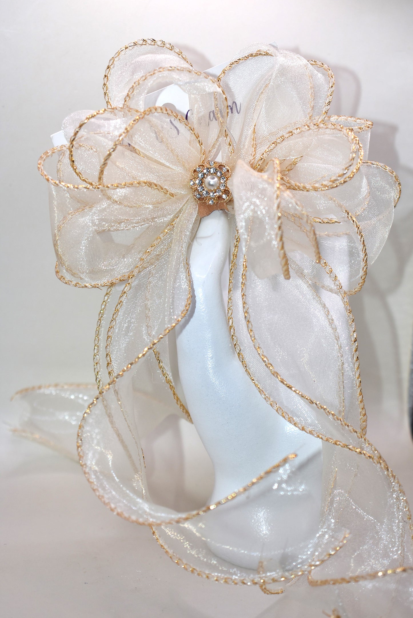 Elevate your ensemble with the Long Tail Collection bow, featuring elegant gold fish tail edging and a stunning gold gem accent. This refined accessory is perfect for any special occasion and suits all ages with its timeless appeal. The alligator-wrapped clip ensures a secure and comfortable fit, adding a subtle touch of sophistication to your look.