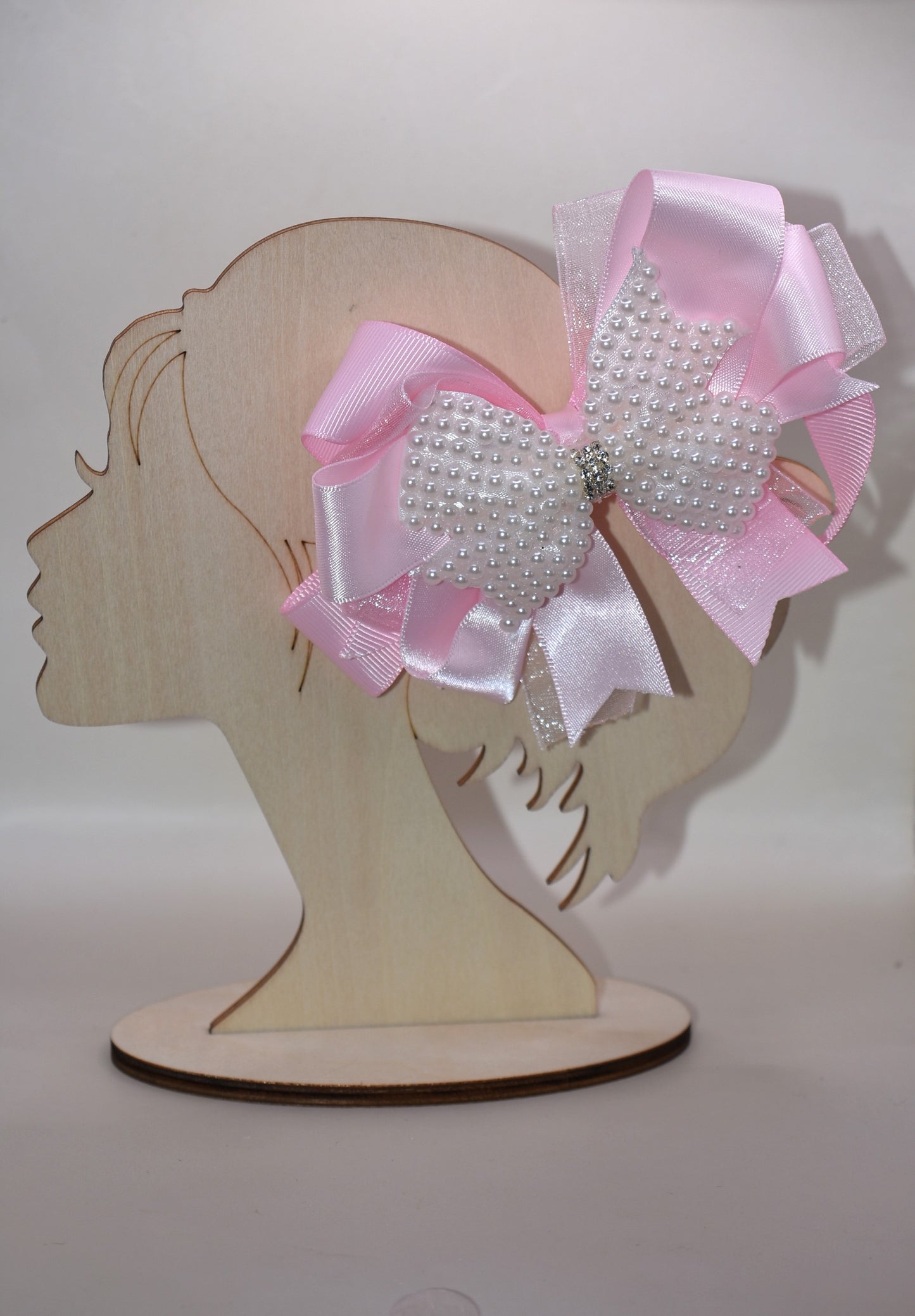 Add a splash of charm with this beautiful pink bow from Nana's Collection! 🌸 Layers of soft pink ribbons create a perfect princess look, topped with a sparkling pearl and crystal wrap ✨. The wrapped alligator clip makes it super easy to wear all day long. Perfect for the little girl who loves everything pink and pretty! 🎀💕