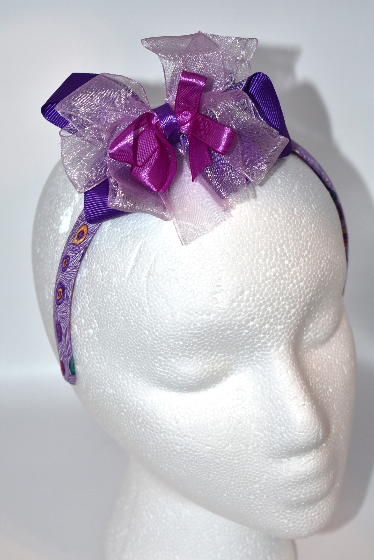 Get ready to turn heads with Nana's Collection Headband 9! 💜 This playful purple headband features layered ribbons that add a fun, stylish pop to any look. Perfect for brightening your day with a splash of color and charm! 🎀✨