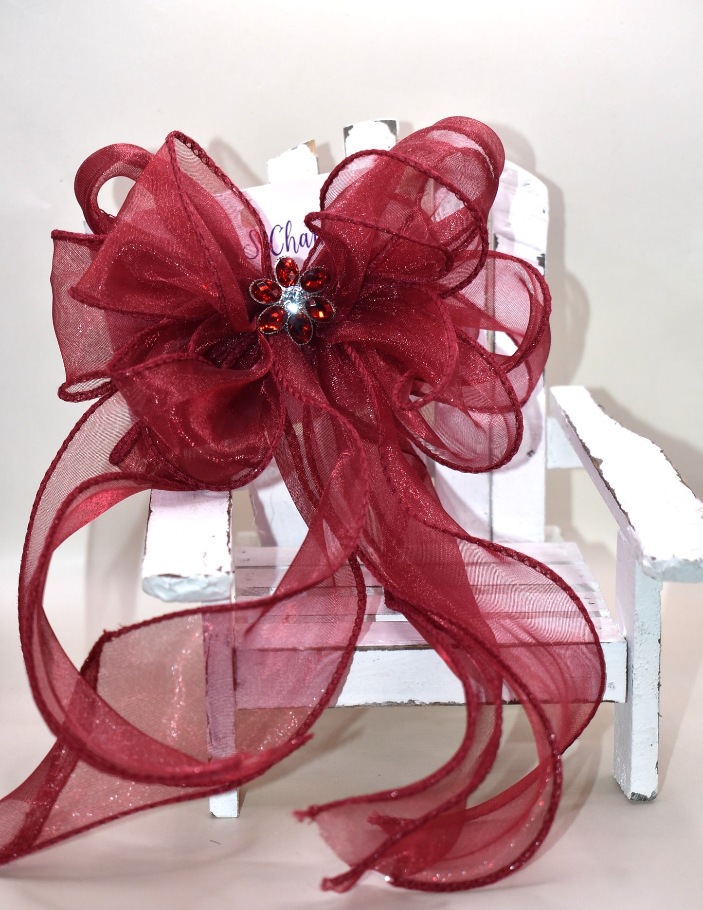 Elevate your ensemble with this elegant long burgundy bow from the Long Tail Collection. Featuring a refined fish tail ribbon design and a sparkling gem centerpiece, it adds a touch of sophistication to any outfit. Securely fastened with a wrapped alligator clip, this accessory combines style and practicality effortlessly.