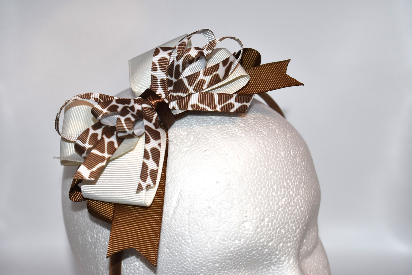 Bring a touch of whimsy to your look with this adorable cow print ribbon headband from Nana's Headband Collection. Featuring a charming brown and cream color combo on a thin satin cocoa brown band, it's as comfy as it is cute—perfect for all-day wear with a playful twist!