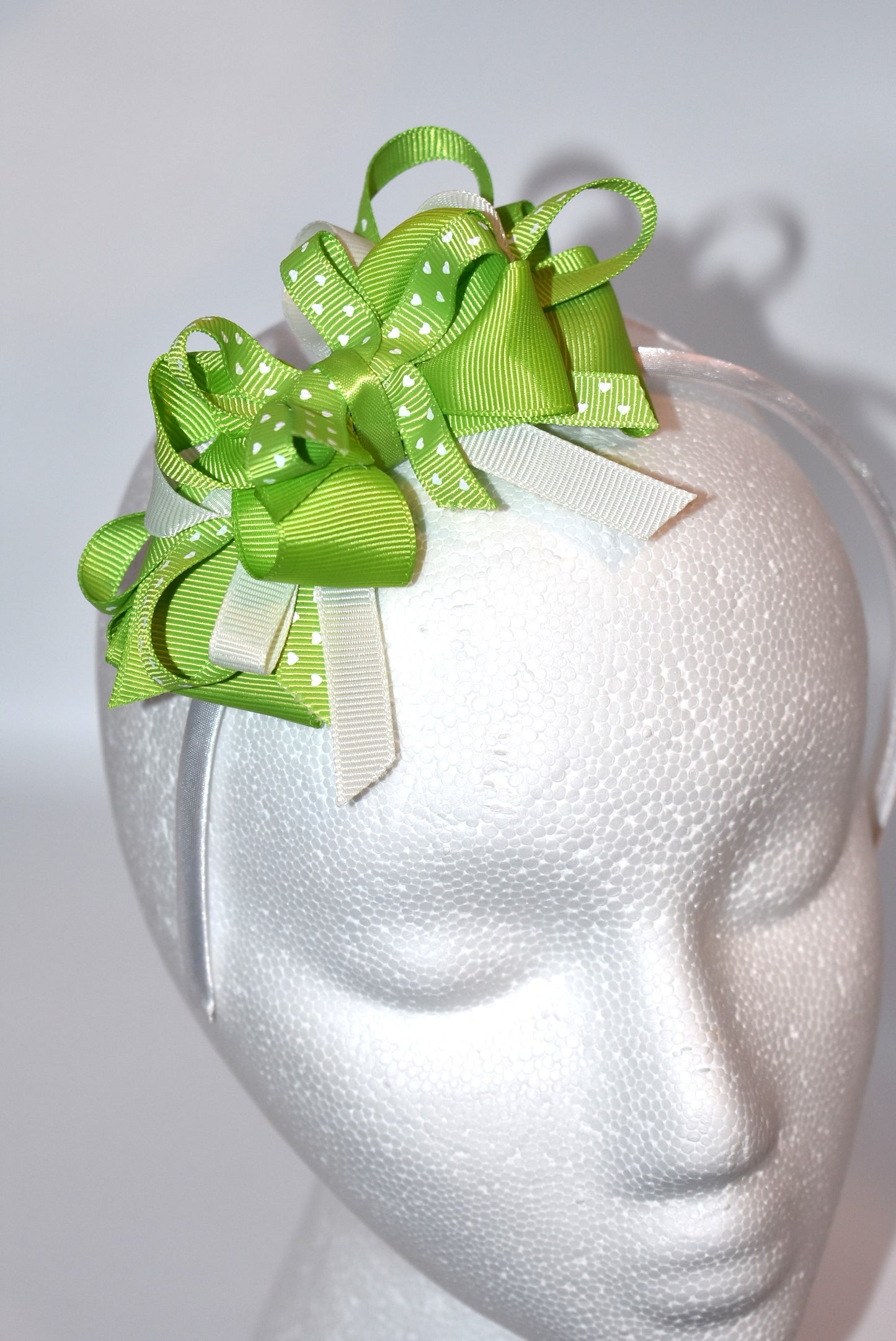 Wrap your hair in whimsy with this adorable skinny satin headband featuring layers of white and green ribbon adorned with pretty green hearts 💚 Perfect for adding a pop of color to any outfit, this lightweight design keeps you comfortable all day long without the fuss. Whether you're dressing up or keeping it casual, this charming accessory brings a playful touch to your look ✨ From Nana's Collection—where style meets sweetness! 🎀