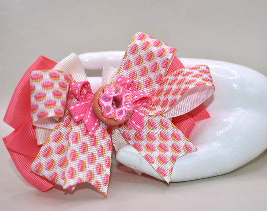 Get ready to sprinkle some sweetness into your day! 🍩 This adorable donut-themed bow features vibrant pink and colorful ribbons layered with playful charm. The wrapped alligator clip on the back makes it super easy to secure in your hair, so you can rock your donut dreams from morning to night. Perfect for anyone who loves a little whimsy and wants to show off their fun side! 🎀✨