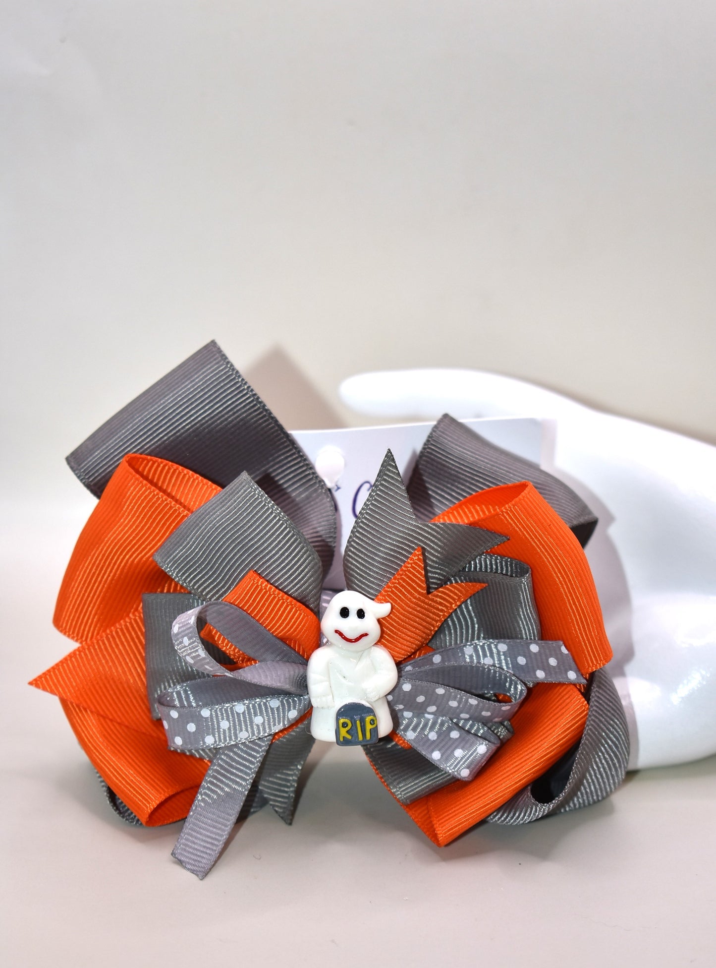 Get into the Halloween spirit with this adorable orange and grey ribbon π topped with the cutest white ghost charm π»! Perfect for adding a festive touch to any outfit, itβs easy to wear thanks to the alligator clip on the back π§‘π€. Spookily stylish and super fun!