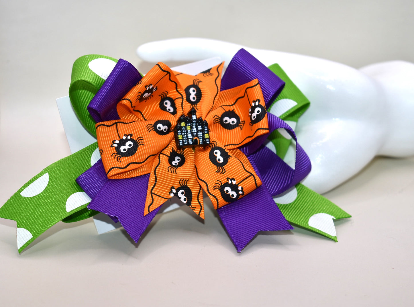 Get into the spooky spirit with this Halloween bow featuring a bold green polka dot ribbon and a charming spider ribbon 🕷️. Topped with an adorable haunted house charm 🏚️, it's the perfect festive accessory. Easy to wear with a wrapped alligator clip on the back — just clip and go! 🎃👻