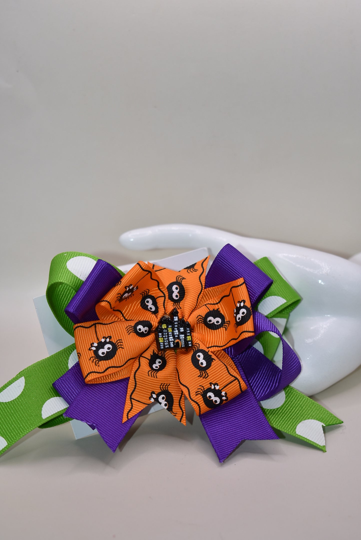 Get into the spooky spirit with this Halloween bow featuring a bold green polka dot ribbon and a charming spider ribbon 🕷️. Topped with an adorable haunted house charm 🏚️, it's the perfect festive accessory. Easy to wear with a wrapped alligator clip on the back — just clip and go! 🎃👻