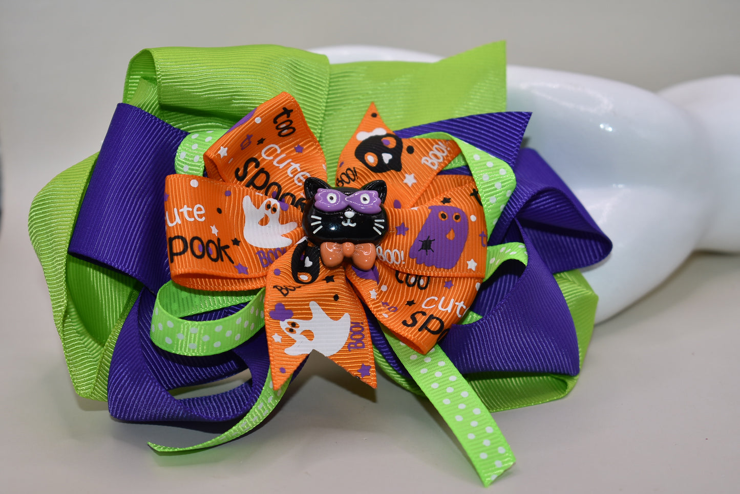 Get ready to sparkle this Halloween with our festive bow 🎀! Featuring layers of vibrant ribbon topped with a cute black cat 🐈⬛, it's perfect for all your spooky fun. Easy to wear with a wrapped alligator clip, this one-of-a-kind accessory adds charm and playfulness to any outfit. Don't miss out—your Halloween look just got a whole lot cuter! 🎃✨