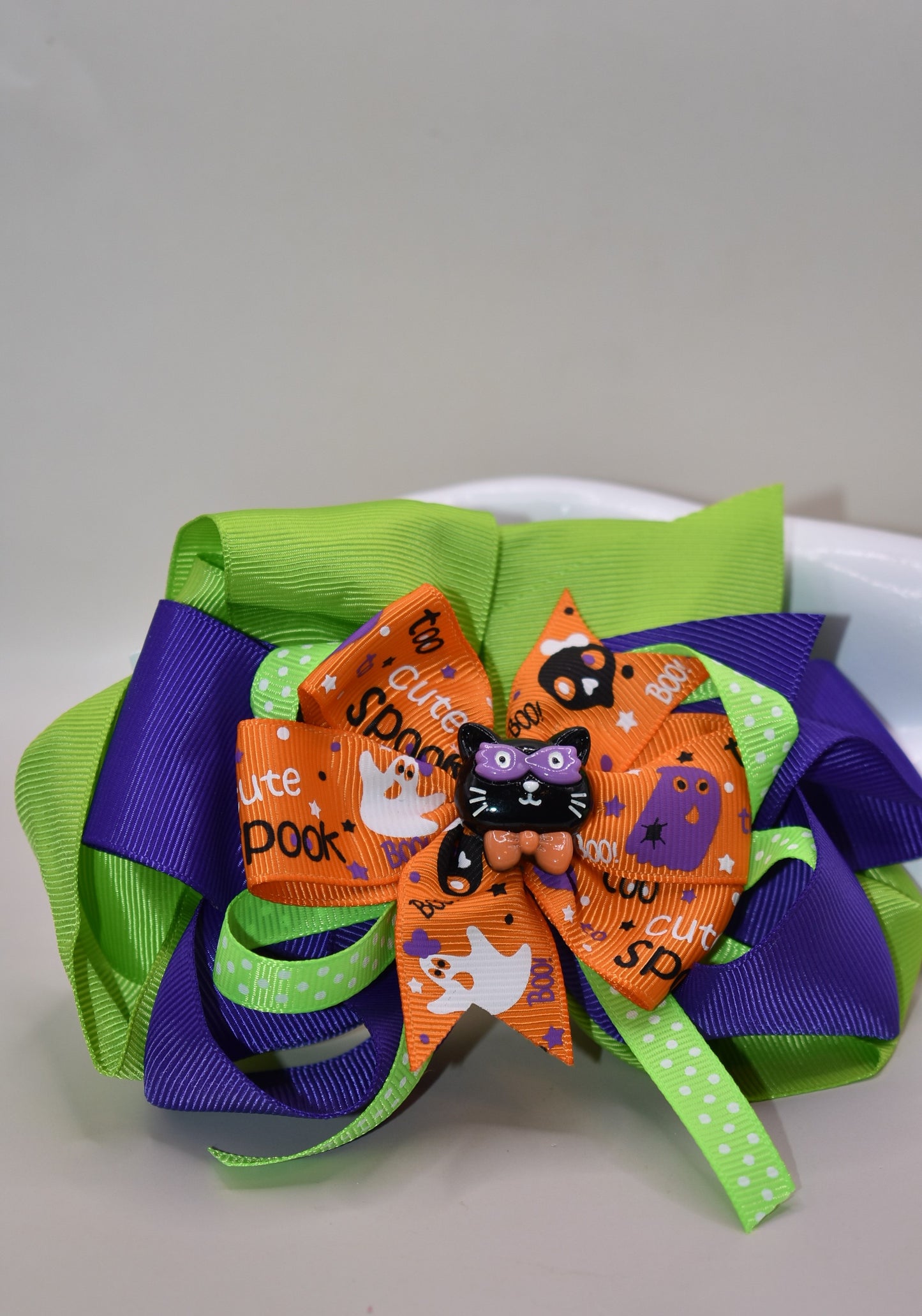 Get ready to sparkle this Halloween with our festive bow 🎀! Featuring layers of vibrant ribbon topped with a cute black cat 🐈⬛, it's perfect for all your spooky fun. Easy to wear with a wrapped alligator clip, this one-of-a-kind accessory adds charm and playfulness to any outfit. Don't miss out—your Halloween look just got a whole lot cuter! 🎃✨
