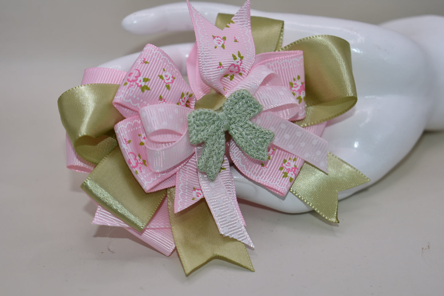 Add some fun and flair to your look with Nana's Collection 39! Featuring a playful mix of sage green and pink ribbons, topped with a cute crochet bow on a polka dot ribbon. Multiple layers of mixed ribbon make it an eye-catching accessory. Comes with a wrapped alligator clip for easy use.