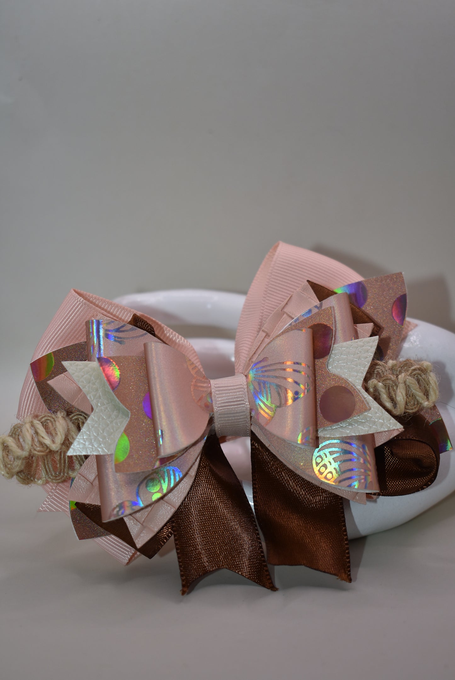 Elevate your style with this gorgeous layered bow clip! 🎀 Crafted from a chic mix of faux leather and silky ribbons in warm peach and rich brown tones, it's the perfect accessory to add personality to any look. Whether you're dressing up for a special occasion or keeping it casual, this versatile beauty works with everything. 💕 The wrapped alligator clip ensures a secure, comfortable fit all day long. ✨ A must-have piece from Nana's Collection!