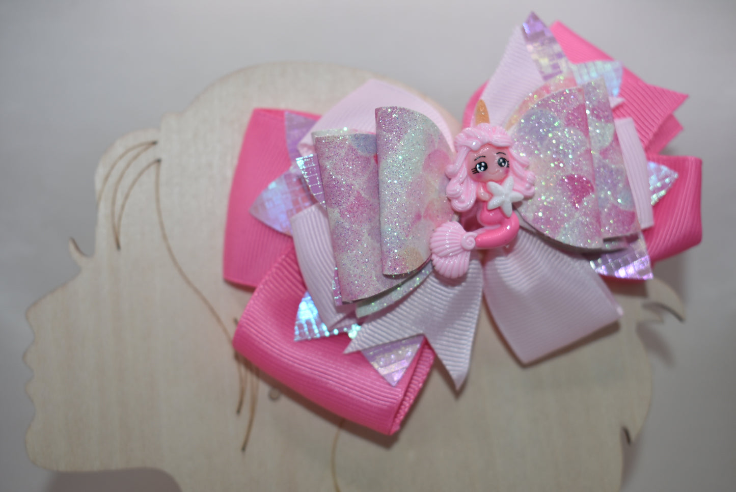 Dive into whimsy with this enchanting mermaid bow! 🧜♀️✨ Featuring layers of luxe faux leather and silky ribbon, this playful accessory is topped with an adorable pink mermaid charm that brings ocean magic to any hairstyle. The covered alligator clip ensures all-day comfort without slipping, making it perfect for little mermaids everywhere. 🎀💕 A splash of charm that's as sweet as the sea!