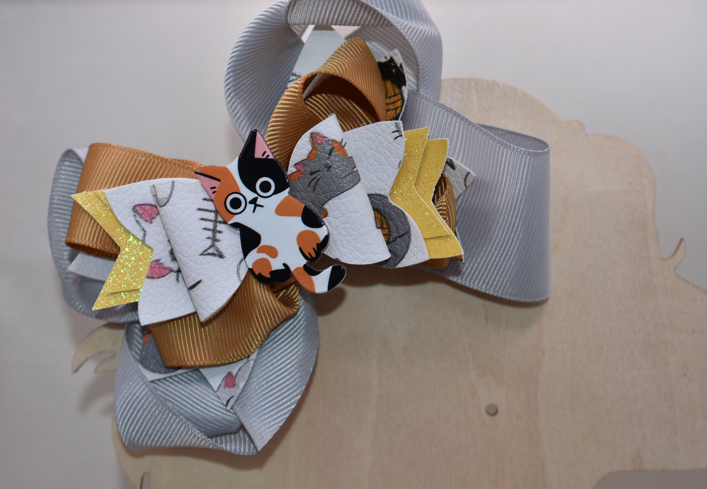 Calling all cat enthusiasts! 🐱 This adorable bow features vibrant cat print faux leather layered with charming ribbon details, topped with an irresistible calico cat charm. 😻 The wrapped alligator clip makes it effortless to secure in your hair, so you can show off your feline love all day long. Purrfect for cat lovers who want to add a playful touch to their style! 🎀