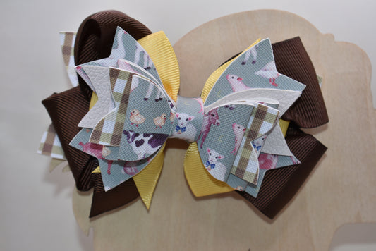 Meet the bow that'll have every farmer grinning from ear to ear! 🌾 This adorable one-of-a-kind animal-themed bow is bursting with personality, featuring layers upon layers of luxe ribbon and faux leather that create serious style depth. 🎀 Whether you're heading to the barn, a country event, or just want to add a touch of whimsy to your everyday look, this charming accessory transforms any outfit into something special. 🐄✨ Nana's Collection brings that perfect blend of cute and quirky that makes you smile