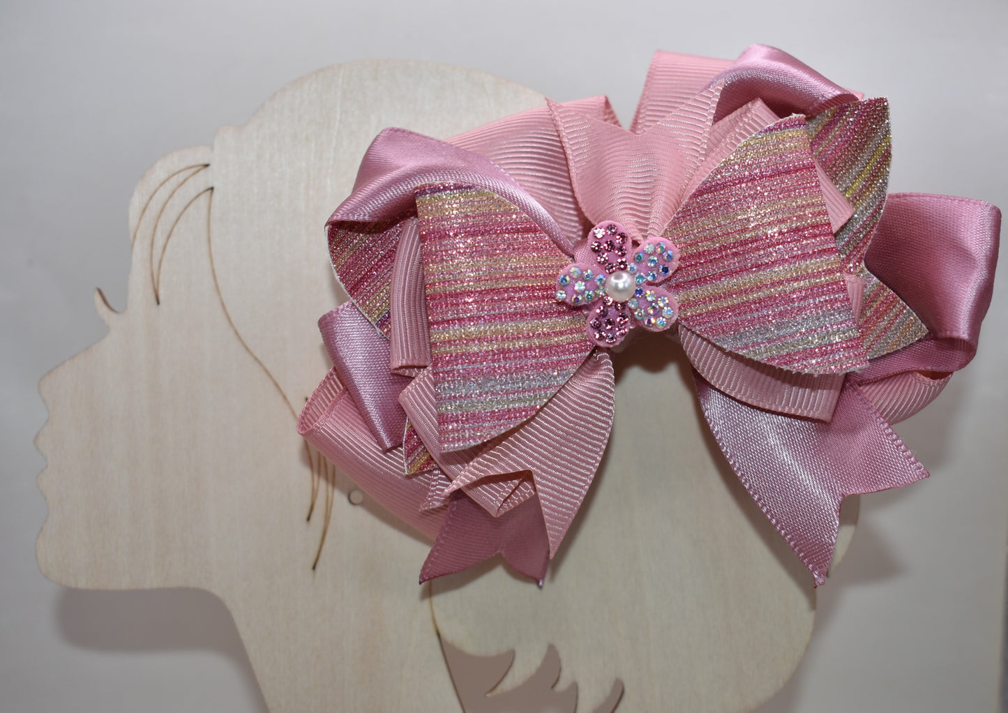 ✨ Introducing a dazzling accessory that brings instant glamour to any hairstyle! This beauty features shimmering glitter faux leather blended with luxe satin and grosgrain ribbon for a multi-textured look that catches the light beautifully. 💎 Topped with an adorable sparkly flower and delicate pearl detail, it's the perfect finishing touch for special occasions or everyday sparkle. The convenient wrapped alligator clip makes it effortless to secure and wear all day long. 🌸 Pure magic for your hair!