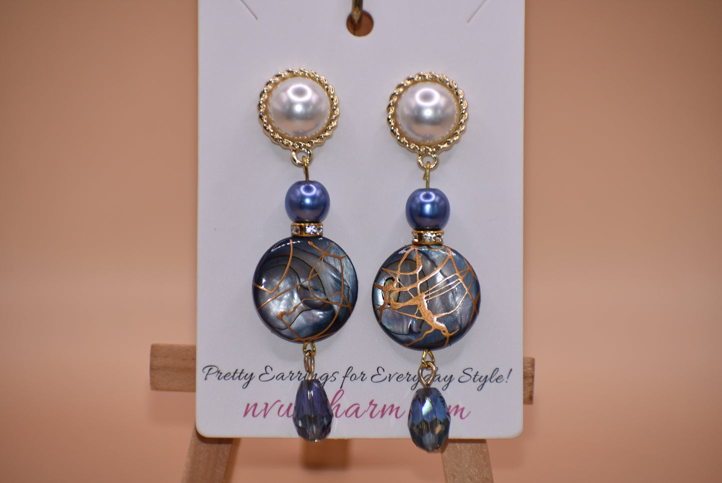 The Blue Collection 22 pearl studs feature a one-of-a-kind design.&nbsp; They are made with beautiful blue pearls and gems and have an eye-catching long hanging shape, perfect for special occasions. Crafted with care and attention to detail, these earrings will stand out.