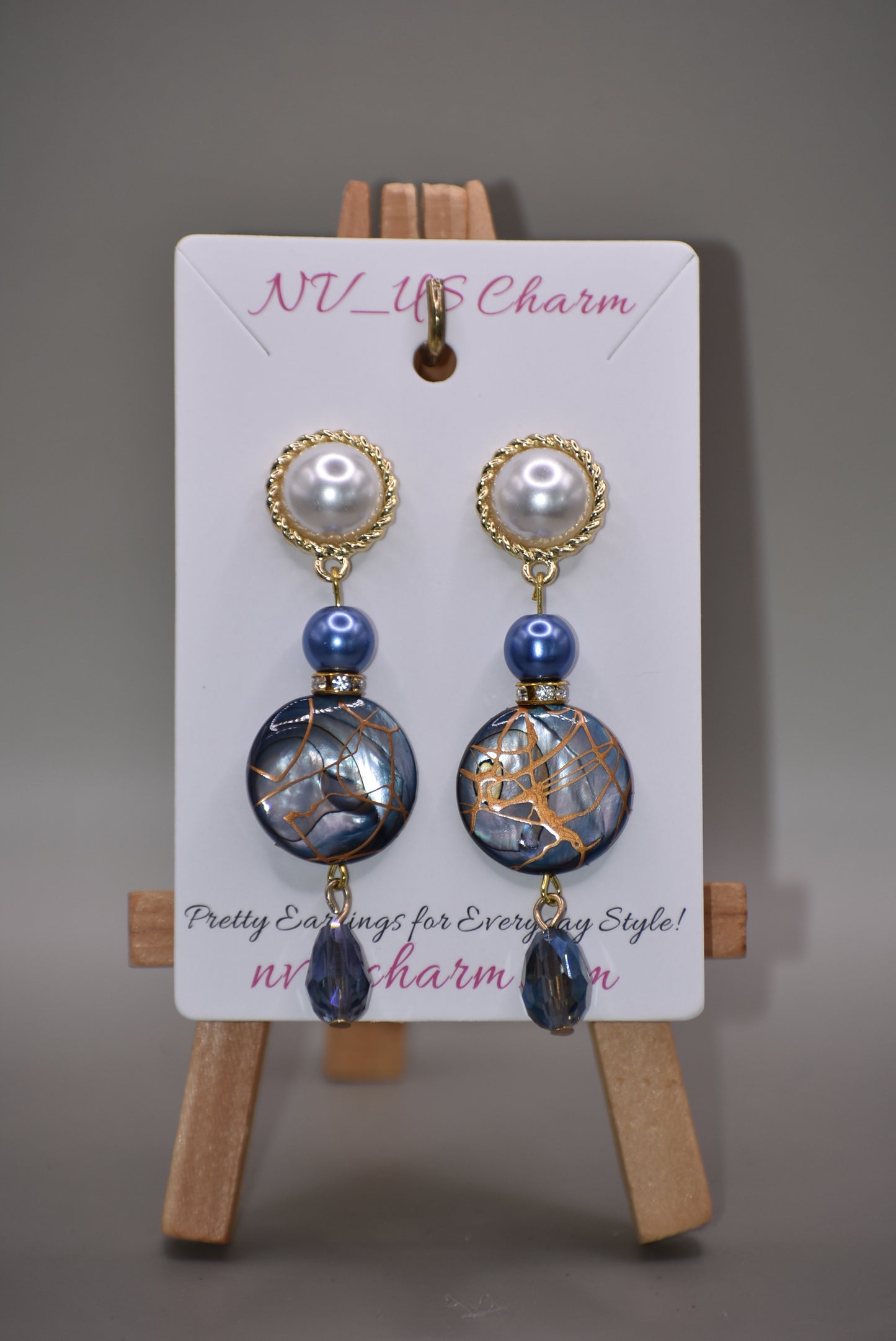 The Blue Collection 22 pearl studs feature a one-of-a-kind design.&nbsp; They are made with beautiful blue pearls and gems and have an eye-catching long hanging shape, perfect for special occasions. Crafted with care and attention to detail, these earrings will stand out.