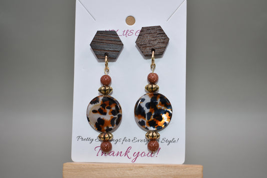 Add some wild fun to your look with our Brown Collection! These unique earrings feature octagon wood posts and a playful leopard print round charm accented with brown and gold beads. At 2 1/2 inches, they're perfect for comfortable, all-day wear. Let your wild side shine through with these earrings!