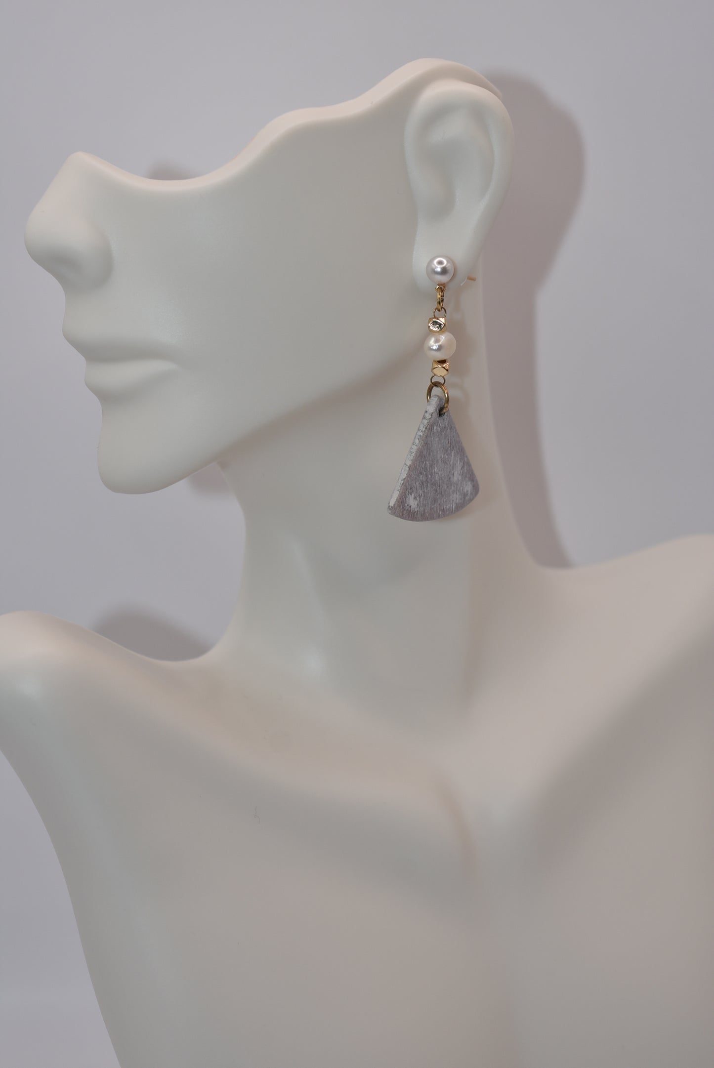 Unleash your inner uniqueness with our Gray Collection. This beautiful one-of-a-kind piece boasts a perfect combination of pretty pearls, gold filled hypoallergenic posts and a playful mix of hanging pearl, bead and wood pieces. Comfortable and easy to wear, it's sure to add a touch of personality to any outfit.