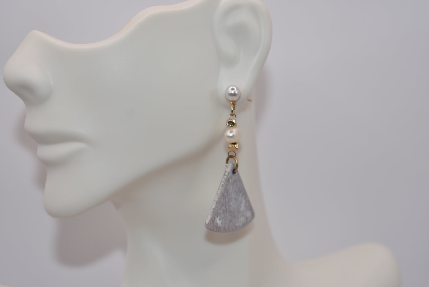 Unleash your inner uniqueness with our Gray Collection. This beautiful one-of-a-kind piece boasts a perfect combination of pretty pearls, gold filled hypoallergenic posts and a playful mix of hanging pearl, bead and wood pieces. Comfortable and easy to wear, it's sure to add a touch of personality to any outfit.