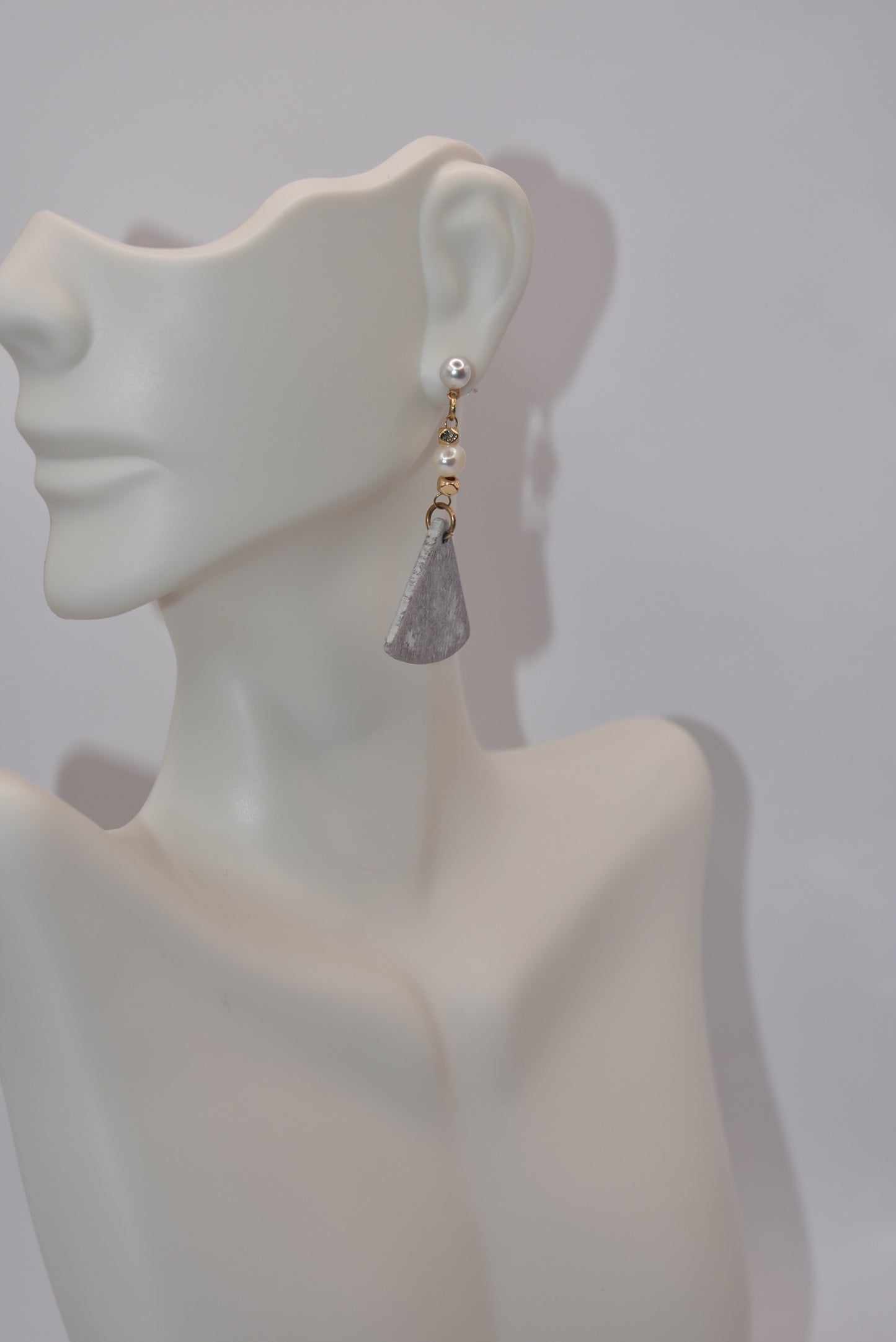 Unleash your inner uniqueness with our Gray Collection. This beautiful one-of-a-kind piece boasts a perfect combination of pretty pearls, gold filled hypoallergenic posts and a playful mix of hanging pearl, bead and wood pieces. Comfortable and easy to wear, it's sure to add a touch of personality to any outfit.