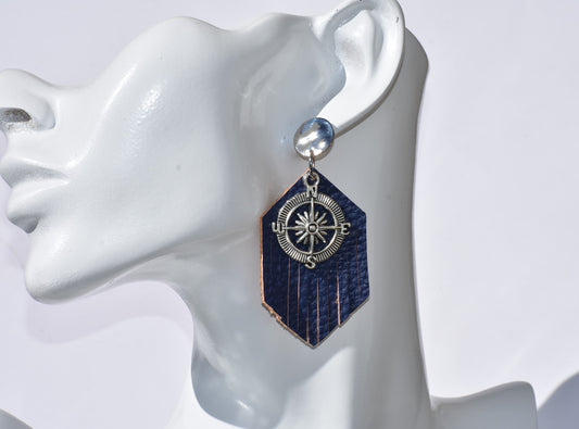 Unlock your inner islander with the Key West Collection! These unique silver plated post earrings bring a cool island vibe, with a navy blue faux leather fringed backdrop and a shiny silver compass charm in the center. Whether you’re sailing away or kicking back on the shore, these earrings will never leave you lost in style!