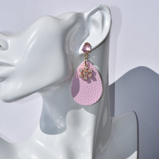 A bold statement for the modern woman! Stand out from the crowd with these one-of-a-kind pink faux leather teardrop earrings. Flirt with the lightweight elegance of a pretty pink crystal charm and gold-filled post. Hypoallergenic for sensitive ears, you'll be sure to fall in love with this pair!