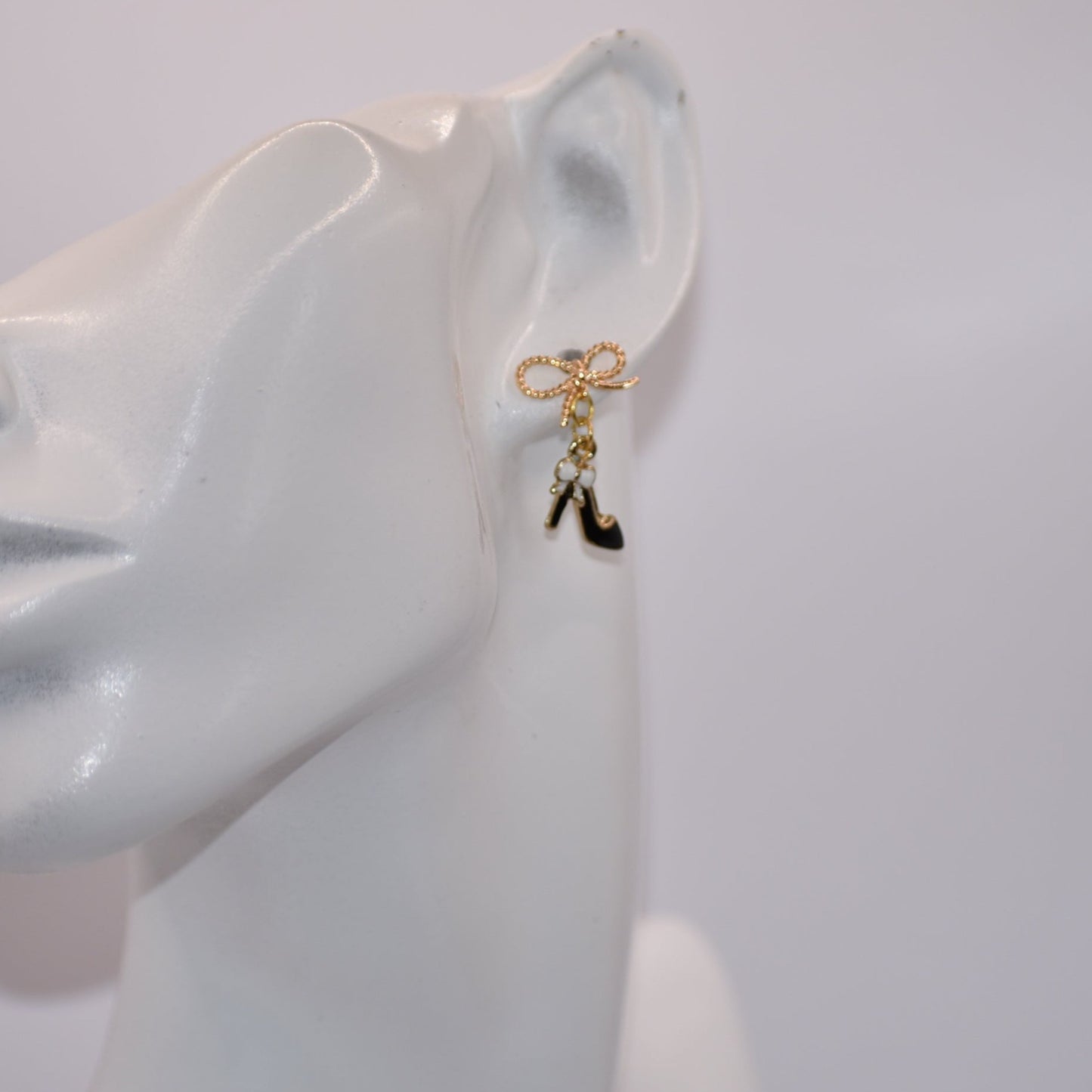 Step up your accessory game with our Black Collection! These high heel shoe earrings, featuring a gold filled hypoallergenic bow, are perfect for adding a touch of chic to your everyday look. Don't miss out on these adorable and versatile statement pieces!