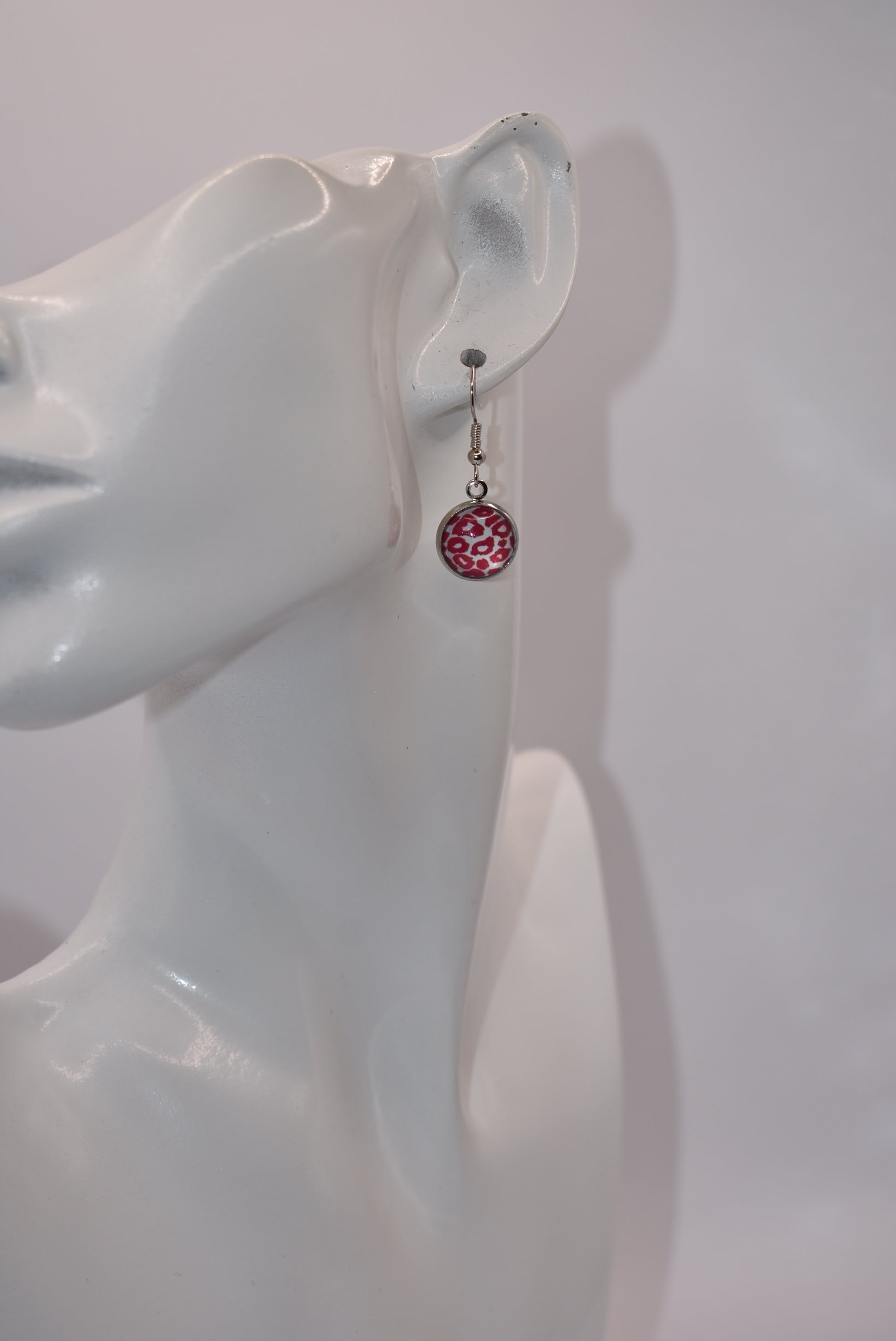 "Add some 🐆🌸 to your outfit with our Safari Collection! These fuschia pink leopard print earrings are not only super cute, but also perfect for sensitive ears with their silver hypoallergenic posts. Get yourself some fun and stylish cabochon hanging earrings today!"