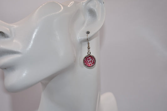 "Add some 🐆🌸 to your outfit with our Safari Collection! These fuschia pink leopard print earrings are not only super cute, but also perfect for sensitive ears with their silver hypoallergenic posts. Get yourself some fun and stylish cabochon hanging earrings today!"